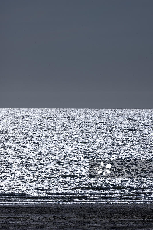 暴风雨气氛：英吉利海峡诺曼底的阳光照耀在银色海面上图片素材