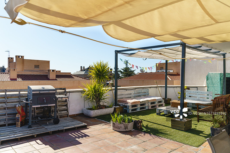 带有白色遮阳篷和烧烤架的现代后院露台图片素材