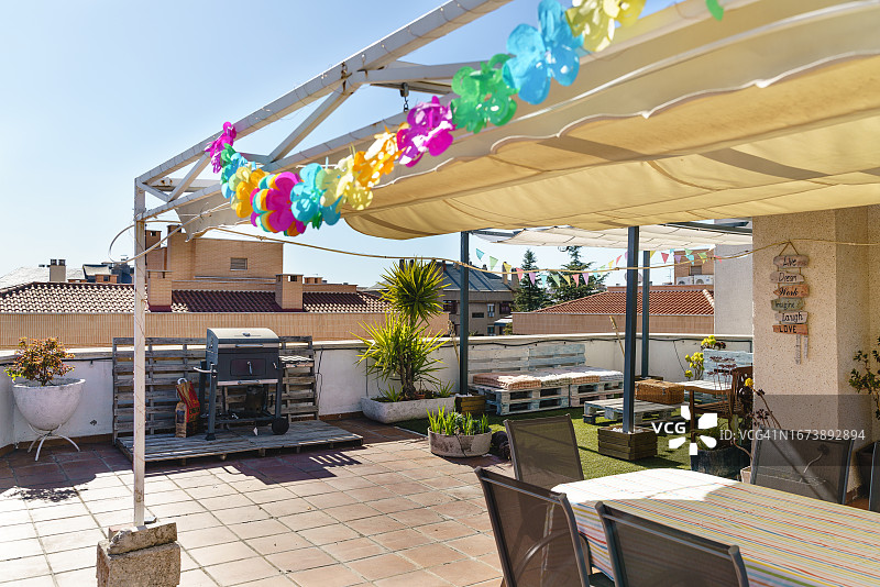 带有白色遮阳篷和彩色生日花环的现代后院露台图片素材