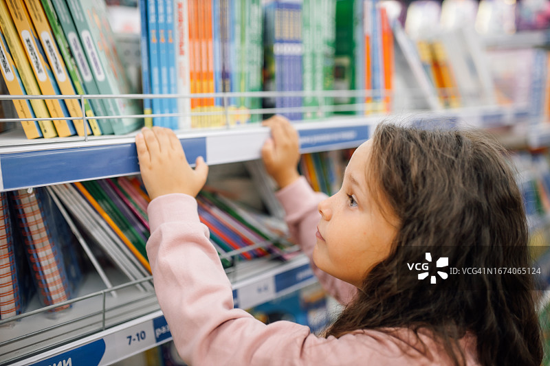 商场文具区年轻女学生看书图片素材