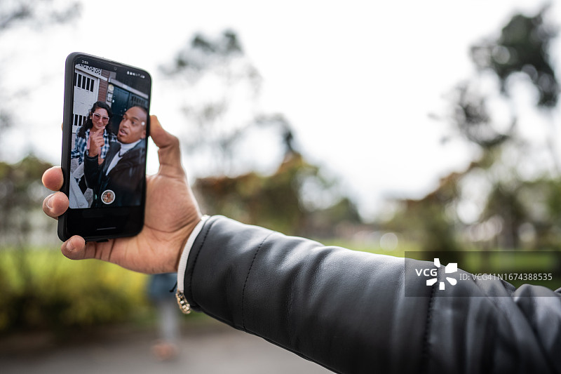 朋友们在城市里聊天并录制社交媒体视频图片素材