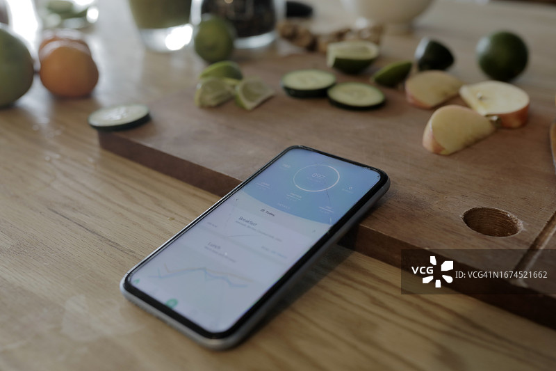 厨房柜台上带有健康应用程序的智能手机特写图片素材