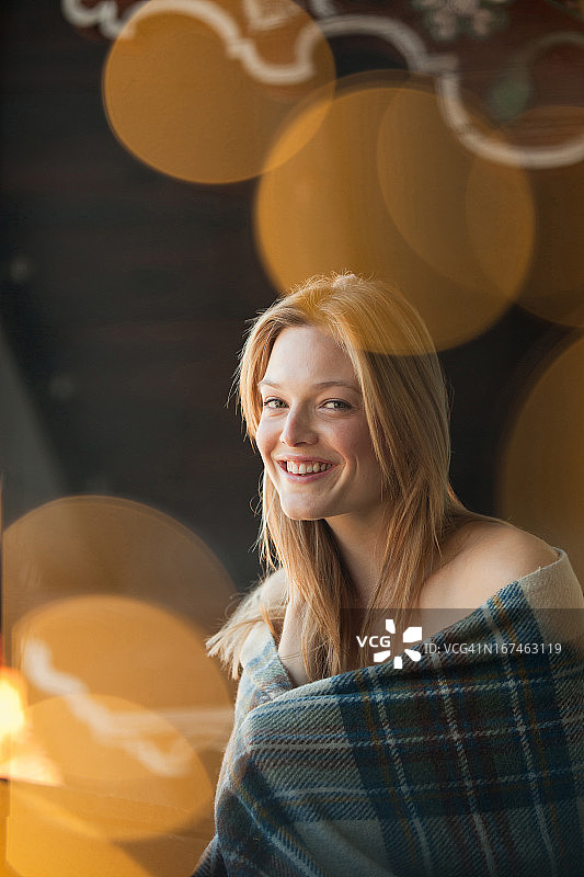 微笑着裹着毯子的女人肖像图片素材