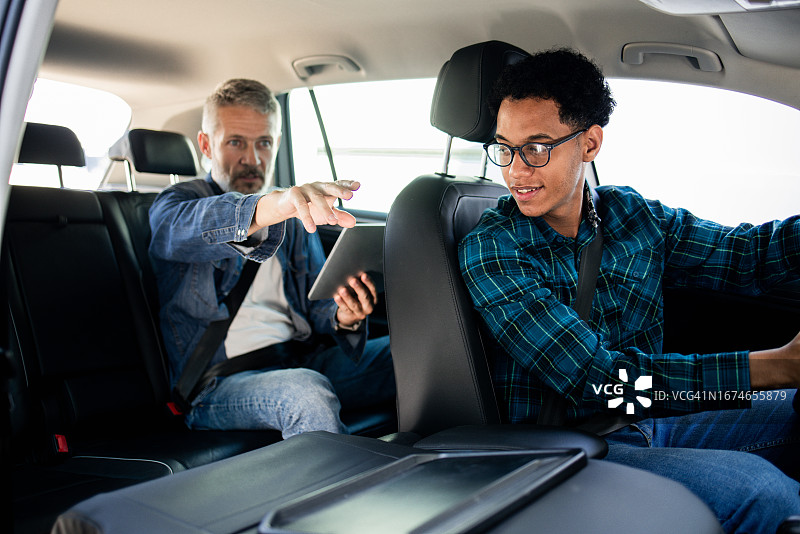 男人向出租车司机指示地点图片素材