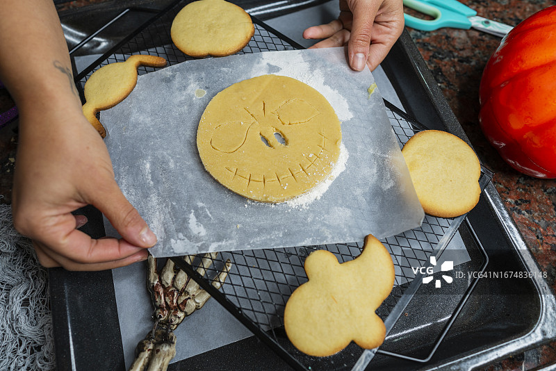 在厨房准备万圣节甜点的拉丁裔糕点师图片素材