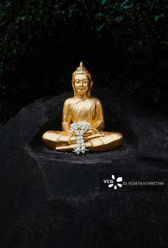 黑色岩石上的金色佛像图片素材