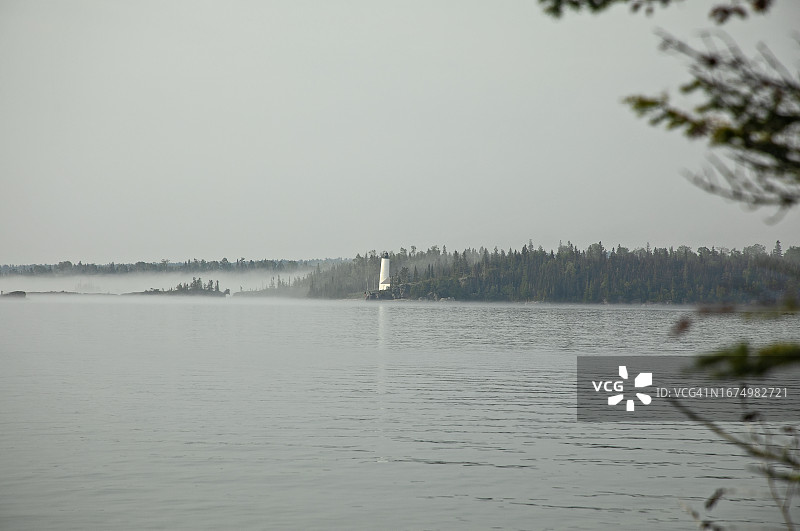 笼罩着群岛岩石港灯塔的雾蒙蒙的早晨图片素材