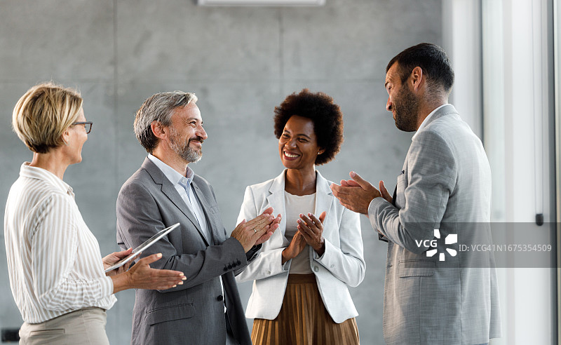 快乐的商业同事在办公室鼓掌图片素材
