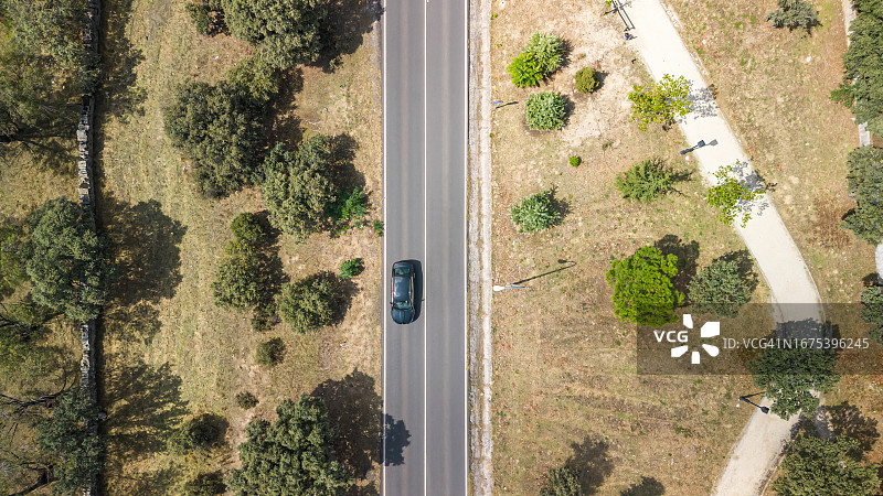 植被道路与蓝色汽车的航拍无人机视角：交通、公路与旅行图片素材