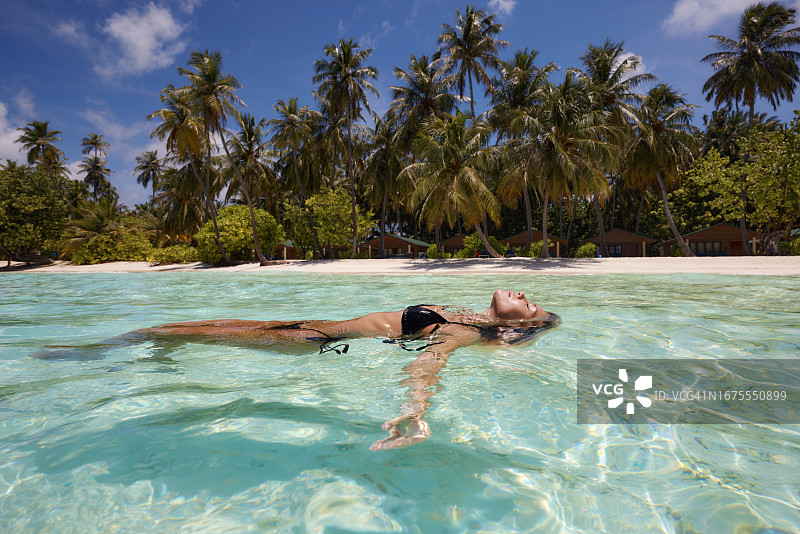 闭着眼睛漂浮在海中的快乐女人图片素材