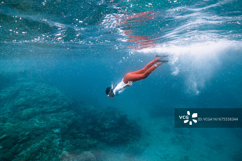 小女孩在蓝色水域浮潜图片素材