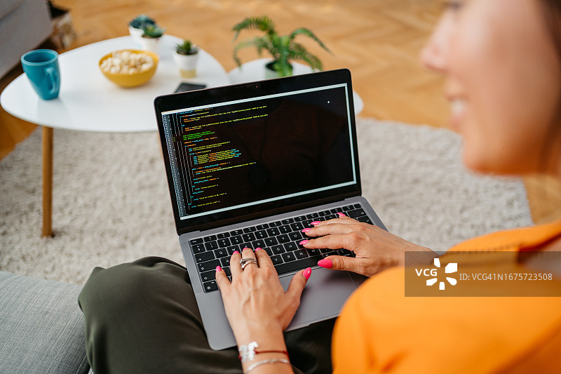 年轻女子在家用笔记本电脑编程图片素材
