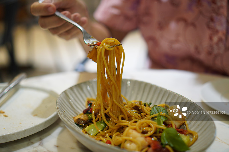 手持叉子卷培根火腿鲜虾意面图片素材