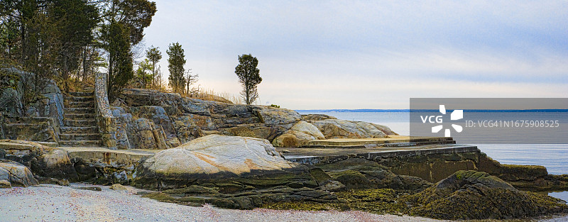 海滩边岩石海岸上的旧混凝土晒台和石阶图片素材