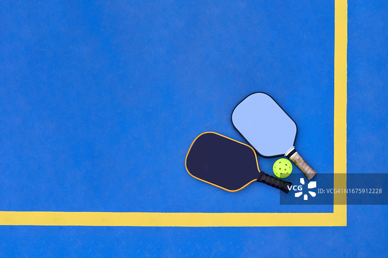 球场上的两个匹克球拍和球图片素材