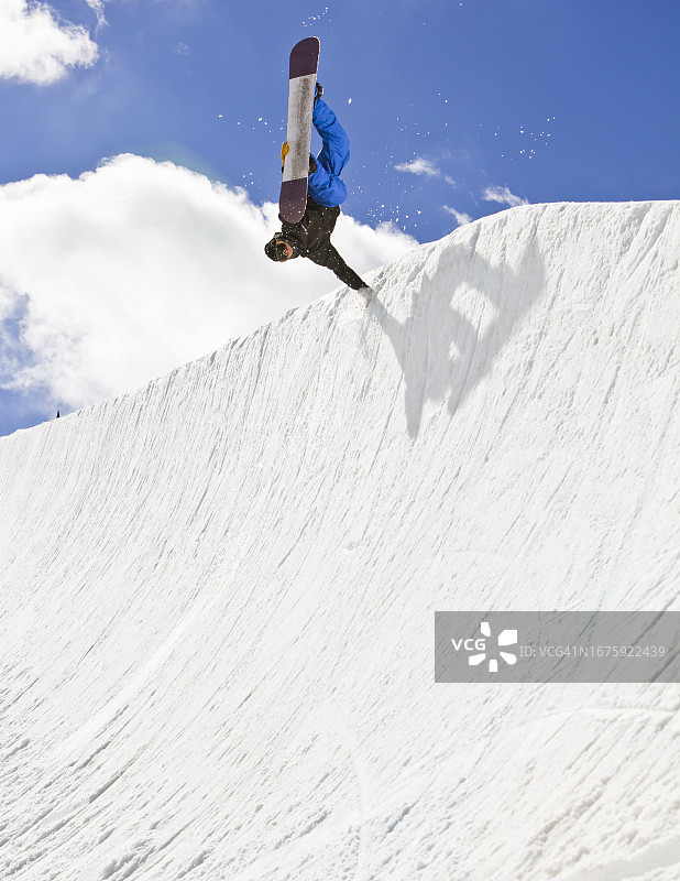 单板滑雪者在U型滑道上滑行图片素材