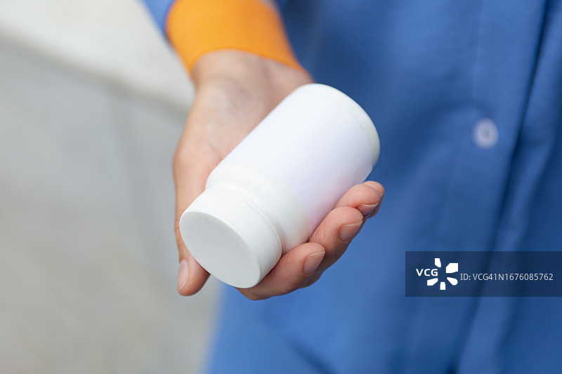 女人手持空白药瓶特写图片素材