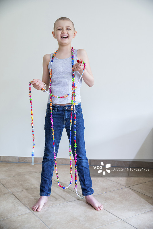 患有白血病的快乐男孩拿着玩具珠子链图片素材