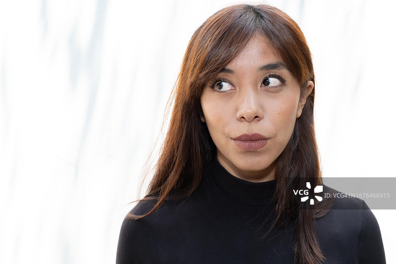 拉丁裔女子看向一边，显得疑惑、犹豫、怀疑图片素材