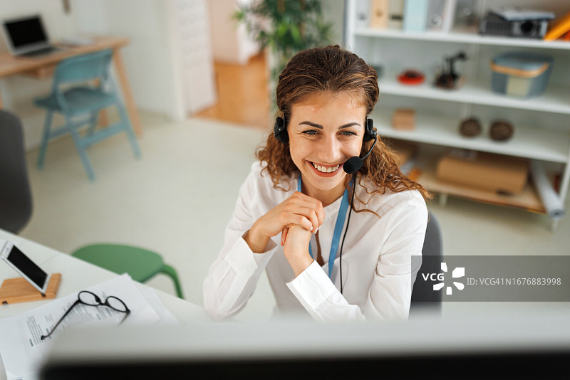 穿着讲究的年轻女人在现代办公室做客户支持图片素材