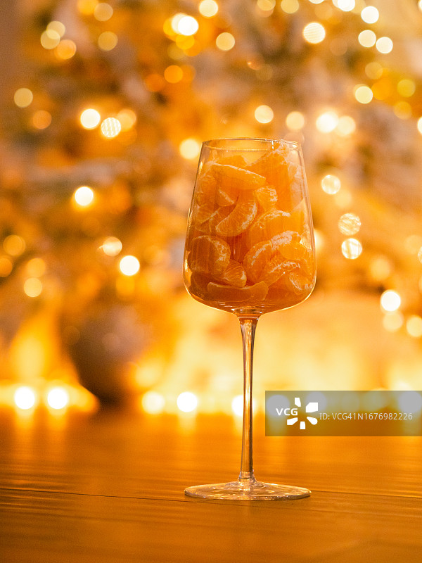 节日散景中，红酒杯里的圣诞橘子图片素材