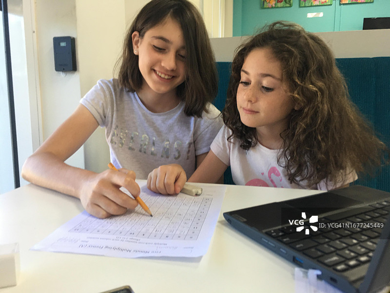 青少年女孩辅导妹妹做作业图片素材