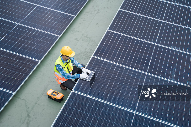 航拍太阳能工程师用电脑检测太阳能电池高压网络图片素材