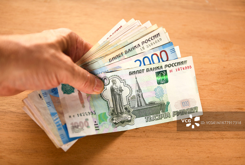 拿着俄罗斯卢布纸币图片素材