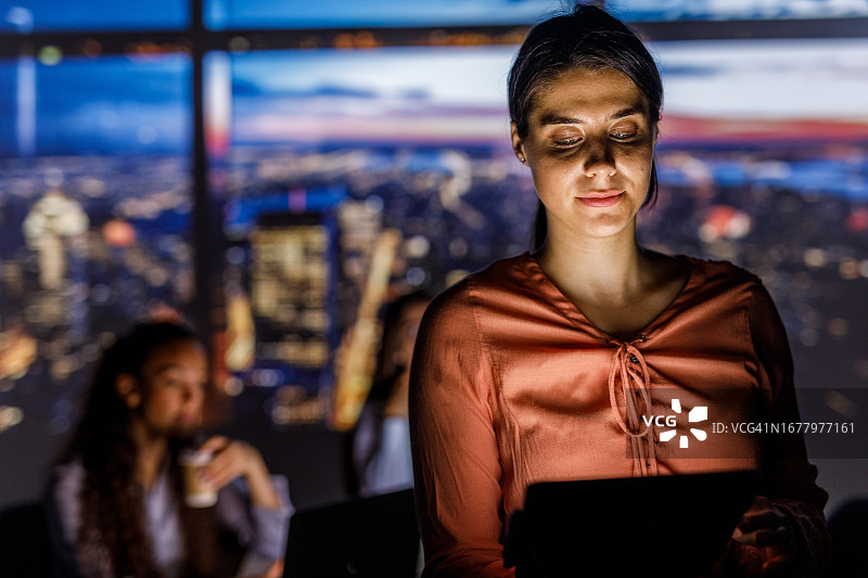 使用平板电脑照亮脸庞的女人图片素材