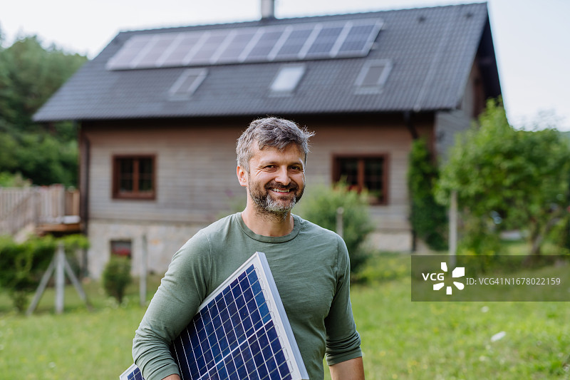 在户外拿着太阳能电池板的男人肖像图片素材