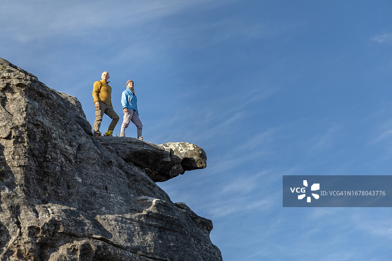 老年夫妇在山上悬崖峭壁上欣赏风景图片素材
