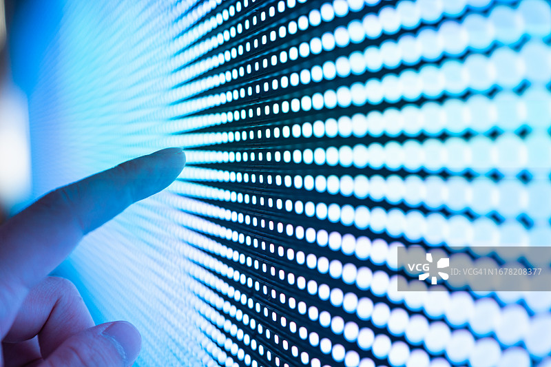 手触摸发光LED显示屏的特写图片素材