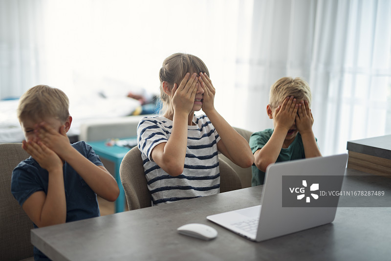 三个孩子在网上看到不适内容后捂住眼睛图片素材