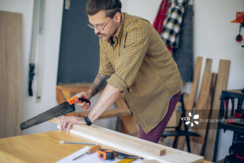 木匠用锯子切割木板图片素材