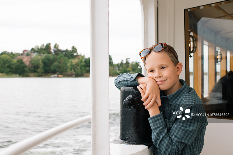 男孩在船上若有所思地笑着看向大海图片素材
