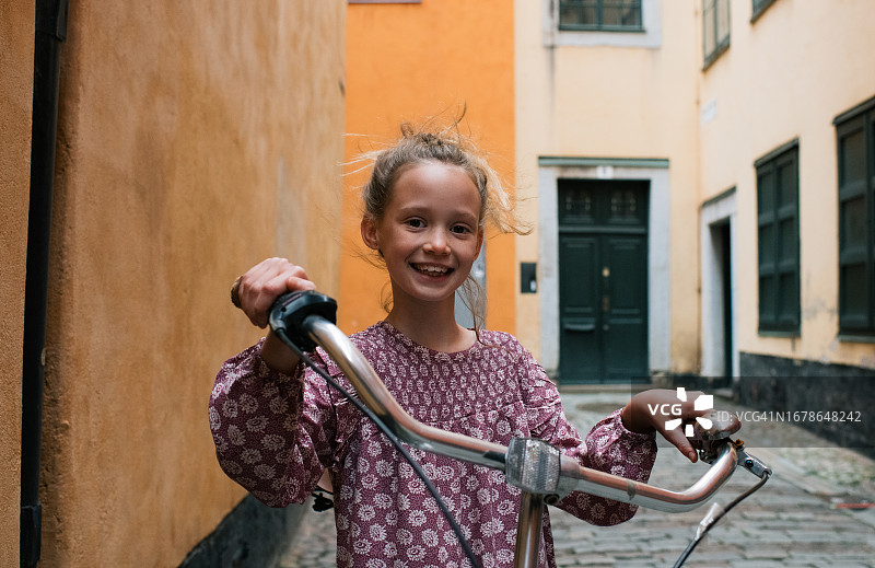 在斯德哥尔摩老城抱着自行车的儿童图片素材