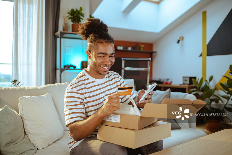 满意的男顾客用智能手机在线购物图片素材