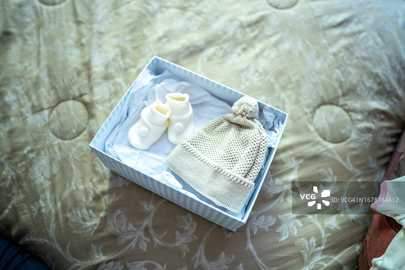 床上放着袜子和针织帽的盒子图片素材