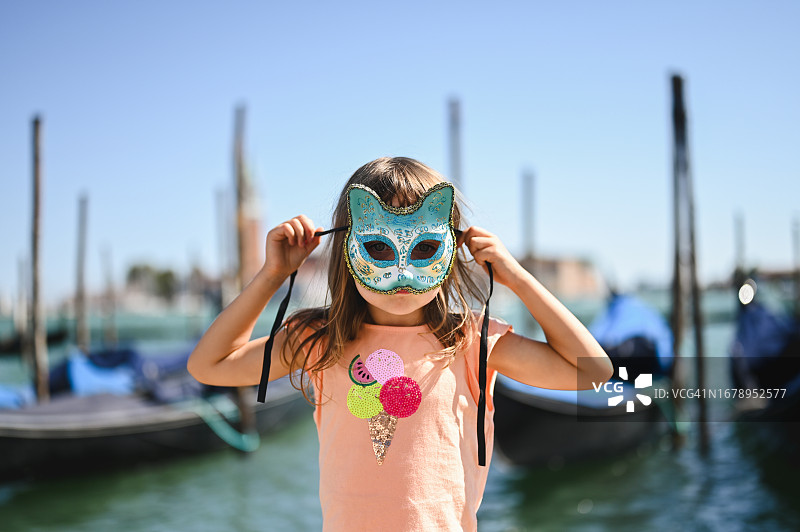 戴威尼斯面具的可爱小女孩肖像图片素材