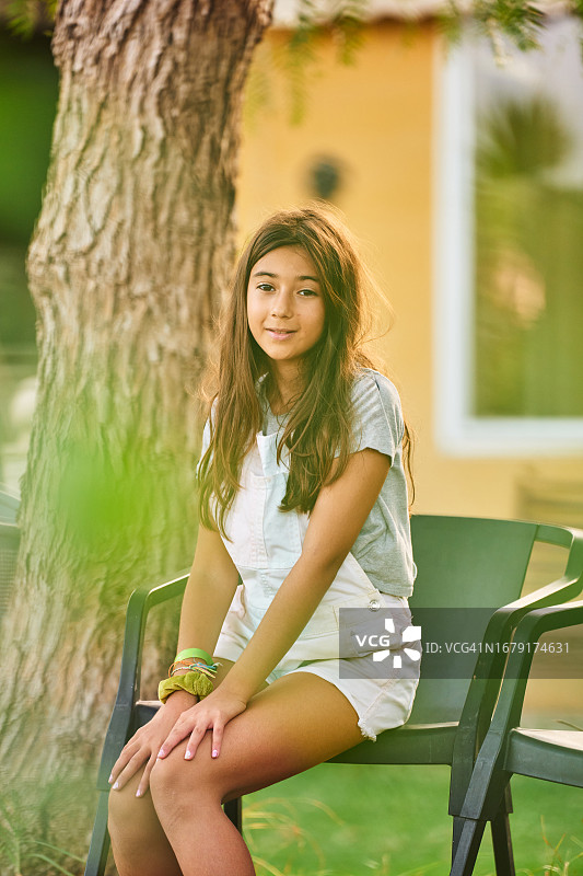 坐在后院椅子上的可爱小女孩图片素材