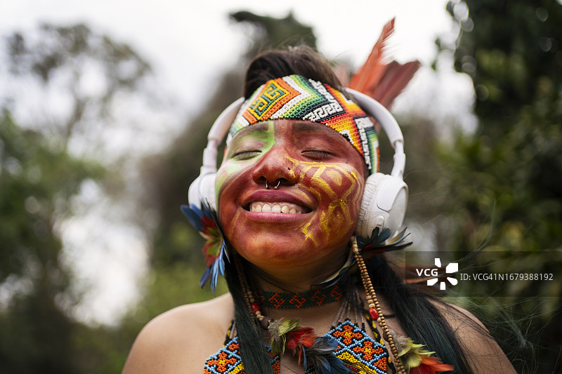 印度妇女使用智能手机和耳机听音乐图片素材