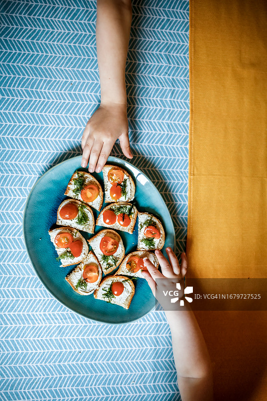 孩子们早上在蓝色盘子上准备素食小三明治，早餐，俯视图图片素材