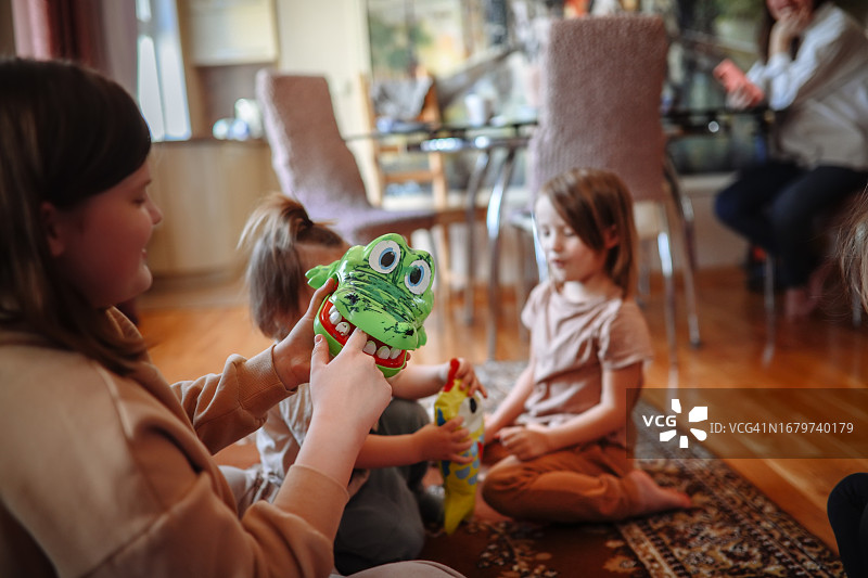 不同年龄段的孩子们一起玩玩具鳄鱼咬手指游戏图片素材