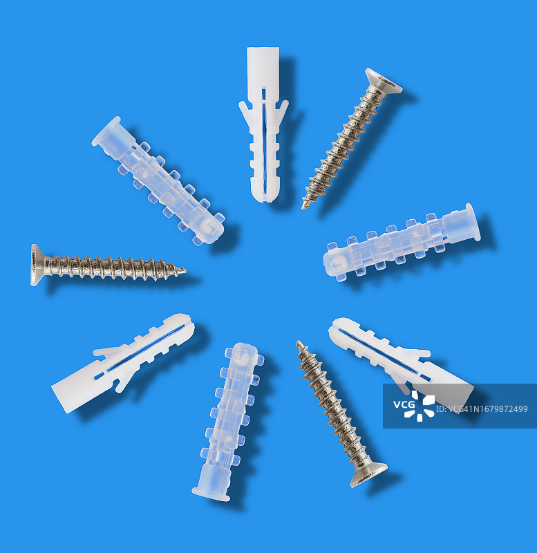 蓝色背景下带有小阴影的螺钉和螺栓特写图片素材