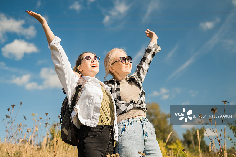 两位女性朋友在山丘远足欣赏美景图片素材