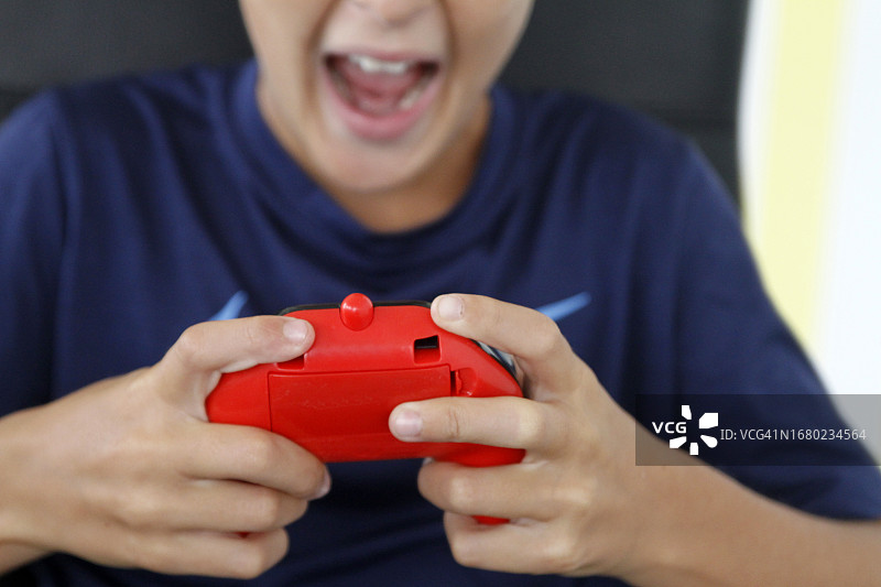 玩游戏机的兴奋男孩特写图片素材