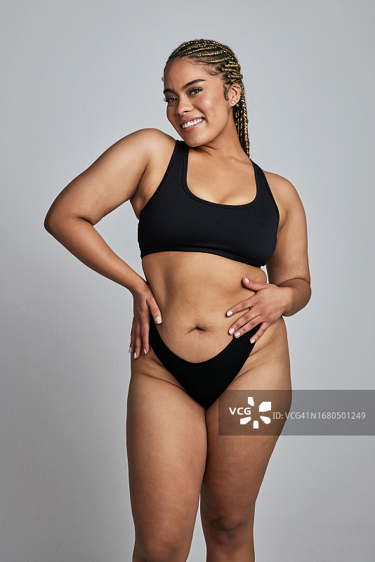 内衣：加大码模特在工作室展示健康、自信和身体积极性。快乐、美丽、自然的女人在灰色背景上微笑，展现护肤、赋权和化妆品图片素材