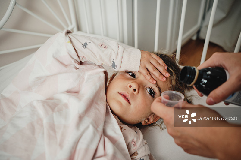 妈妈给女儿喂止咳糖浆图片素材