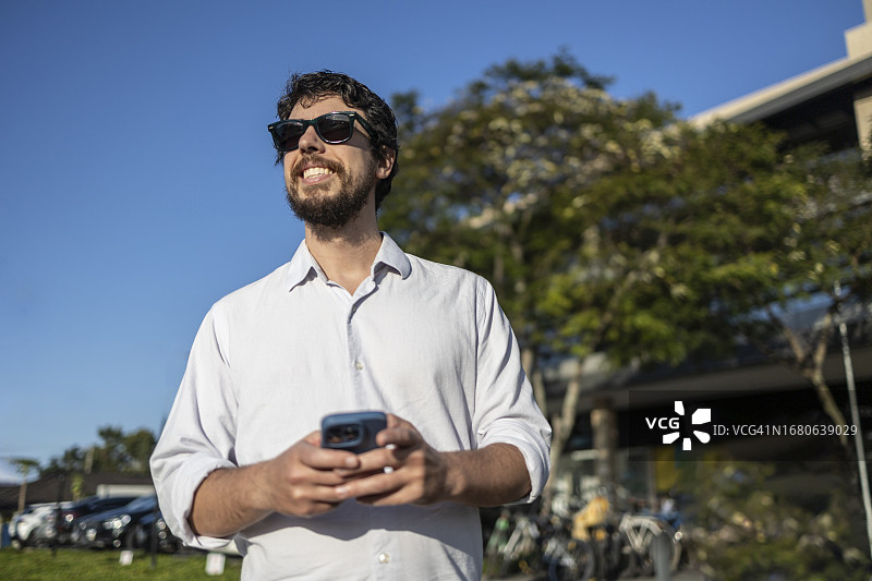 戴墨镜的男人正在用App等车图片素材