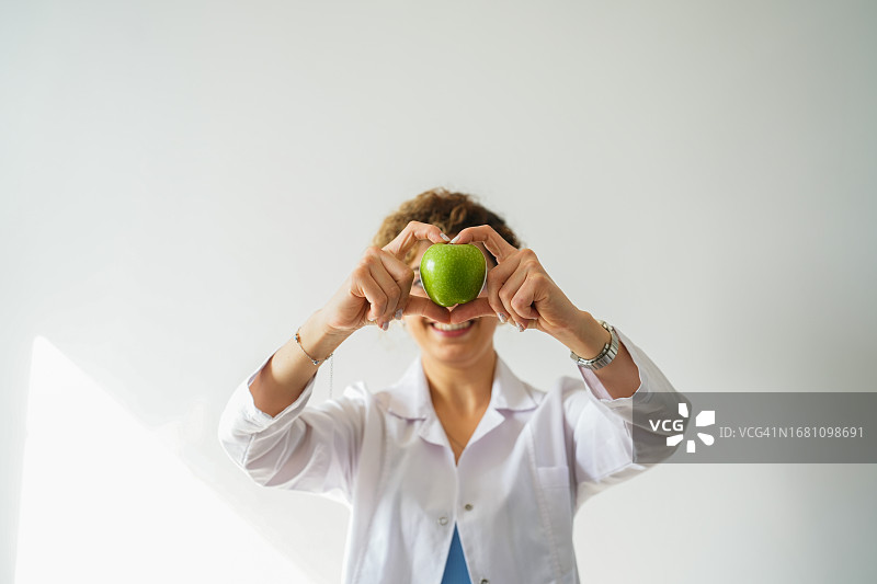 女营养师用苹果比心，健康生活方式图片素材
